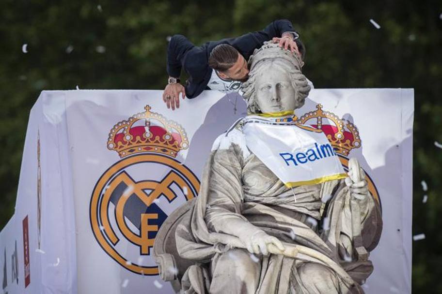 Sergio Ramos bacia la statua di Cibeles dopo averle legato al collo la bandiera del Real. Afp 